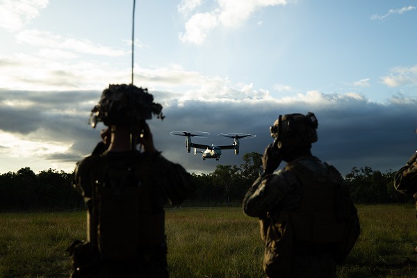 Queensland, Australia. (August 22, 2022): In this photo by Corporal Cedar Barnes, U.S. Marine Corporal Luc Cogger, a radio operator with Lima Company, 3rd Battalion, 7th Marine Regiment and Sergeant Terrance Jones, a joint terminal attack controller, guide an MV-22 Osprey assigned to Marine Rotational Force Darwin to a safe landing during mass casualty event exercises at Australia’s Shoalwater Bay Training Area.  U.S. Marines are returning to six-month deployments to the land down under after a three-year hiatus due to COVID 19 restrictions. 