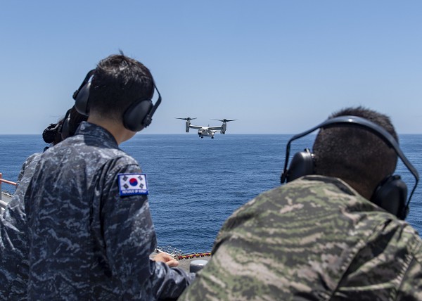 Pacific Ocean. (August 31, 2022): In this photo by Communications Specialist 2nd Class Brett McMinoway, U.S. Navy Sailors join members of the Republic of Korea Navy as they observe a CMV-22 Osprey tilt-rotor aircraft landing on the amphibious assault ship USS Essex.  Assigned to the U.S. 3rd Fleet, the Essex and her crew routinely operate with their South Korean counterparts conducting flight operations to counter potential aggression from North Korea.