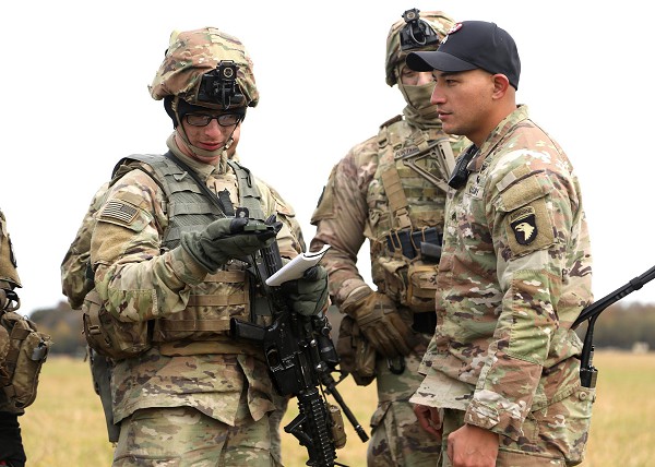 Fort Campbell, KY. (September 9, 2022): In the photo by Staff Sergeant Joshua Tverberg, Private First Class Tanner Chaney, an infantryman with A Company, 1st Battalion, 327th Infantry Regiment, 101st Airborne Division (Air Assault), shoots an azimuth with his compass to determine a landing zone as Sergeant Brandon Quintalla, an instructor with the Sabaluski Air Assault School, supervises during training at Corregidor Drop Zone, Fort Campbell, Kentucky. These are today’s version of Screaming Eagles who fought so courageously in Afghanistan and continue to defend our nation to this day.