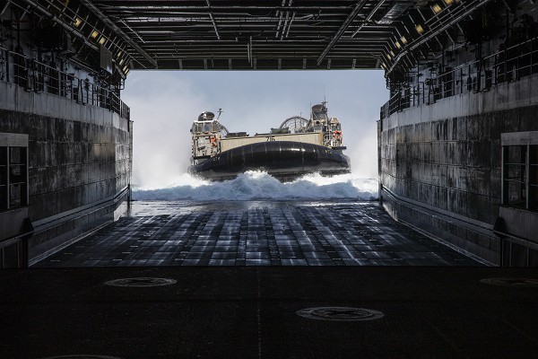 Camp Pendleton, CA. (May 22, 2022): In this photo by Marine Corporal Garrett Kiger, U.S. Navy Landing Craft attached to Assault Craft Unit 5 prepare to enter the well of the amphibious transport dock USS Portland after transporting personnel and equipment from the famed 15th Marine Expeditionary Unit.  