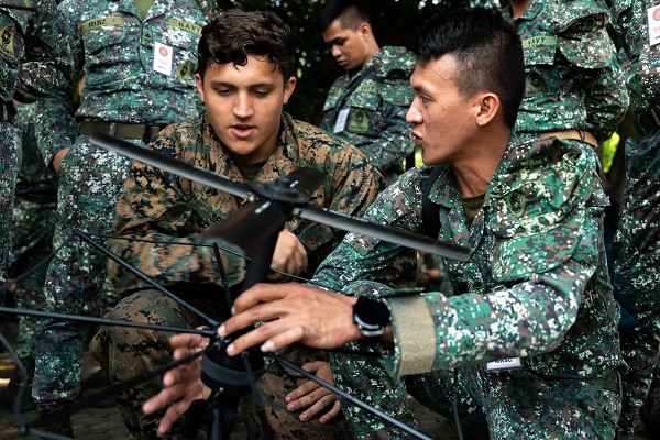 Fort Bonifacio, Philippines. (October 12, 2022) In this photo by Corporal Ujian Gosun, Marine Corporal Brandon Sell, a radio operator with the 3rd Marine Division, practices using a Mini-Secure Communications Controller with Philippine Marines. This secure communications device can simultaneously connect with many distinct types of allied radios, even cell phones.  American and Filipino Marines are participating in Kamandag exercises or “Cooperation of the Warriors of the Sea,” to strengthen interoperability, trust, and cooperation built over decades of shared experiences.