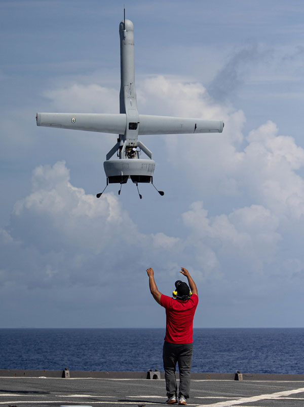 Aboard the USS Rushmore, Philippines Sea. (October 19, 2022): In this photo by Lance Corporal Manuel Alvarado, a civilian contractor prepares to launch a V-BAT drone from the deck of the Marine amphibious dock landing ship USS Rushmore while on patrol in the Philippine Sea. The V-BAT is a platform for intelligence gathering, surveillance, and reconnaissance that requires no launch equipment, making the system ideal for expeditionary operations.