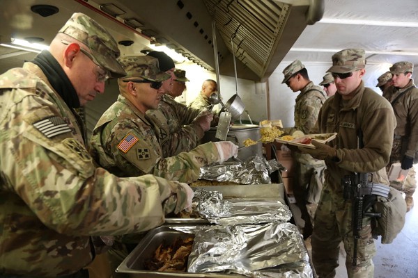 Seoul, South Korea. (November 23, 2017): In the photo by Sergeant Brian Chaney, U.S. Army Soldiers assigned to 2nd Battalion, 4th Field Artillery, 75th Fires Brigade serve food to their fellow Soldiers for a Thanksgiving meal in South Korea. Thousands of American servicemembers, like these, will spend the holidays far from home.
