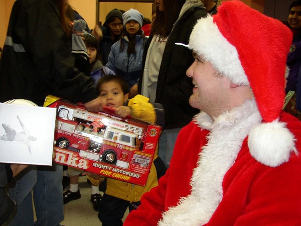 Juneau, Alaska (December 23, 2021): In this photo by Lieutenant Junior Grade Rebecca Chambers, Coast Guard Petty Officer Clinton P. Mooers (aka Santa) is all smiles after handing out Christmas gifts to children in Angoon recently. Mooers is a crewman aboard the Auke Bay-based cutter Liberty who participated in this year’s annual food, blanket, and toy drive in Southeast Alaska. The Auke are an Alaskan Native people, whose autonym Aakʼw Ḵwáan means "Small Lake People”, and they are a subgroup of the Tlingit tribe.